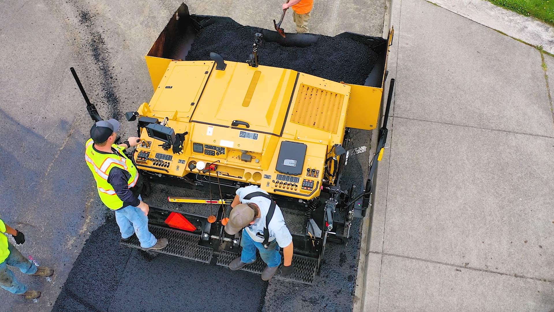 top view of asphalt paving machine with two employees