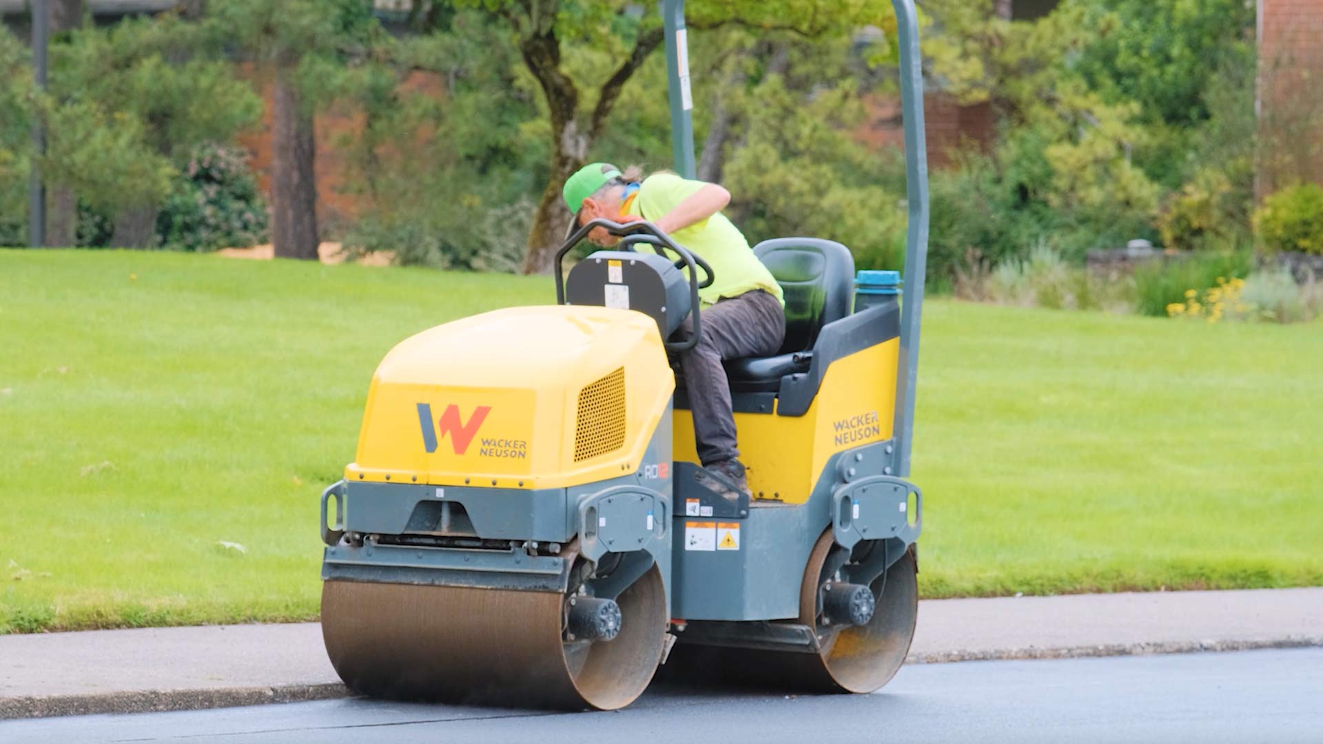 employee on paving roller along curb